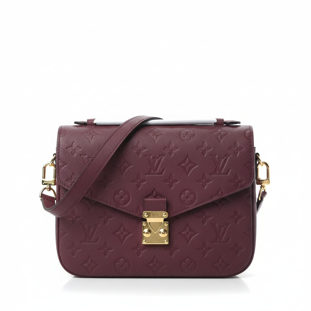 Maroon handbag with gold accents on a white background