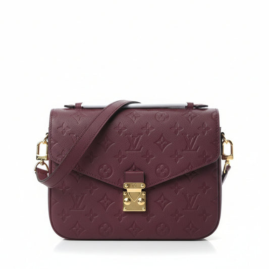 Maroon handbag with gold accents on a white background